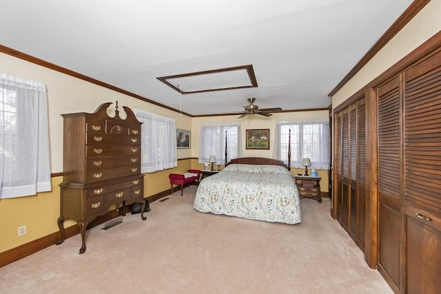 bedroom with light carpet, ceiling fan, crown molding, and multiple closets