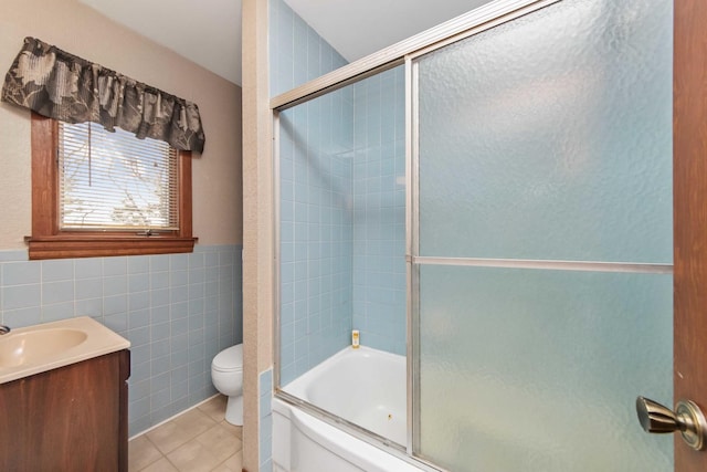 full bathroom featuring enclosed tub / shower combo, tile walls, vanity, tile patterned floors, and toilet