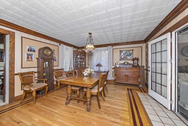 dining room with ornamental molding, light hardwood / wood-style floors, and a chandelier