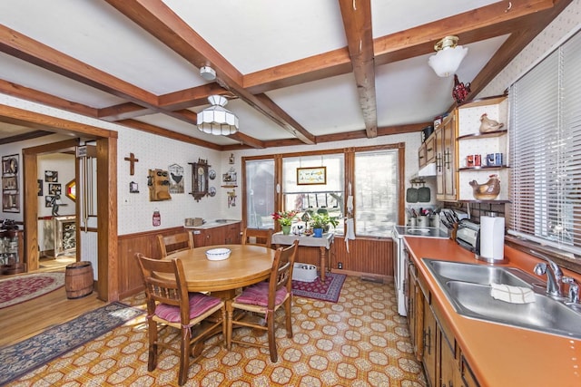 dining space featuring coffered ceiling, sink, and beam ceiling