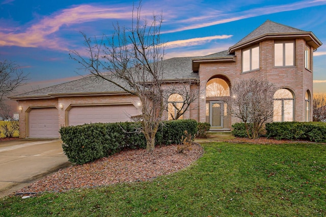 view of front of house with a garage and a yard