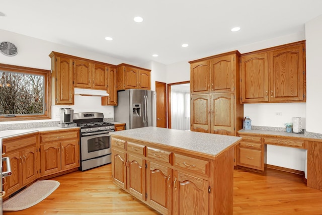 kitchen with stainless steel appliances, a center island, a wealth of natural light, and light hardwood / wood-style floors