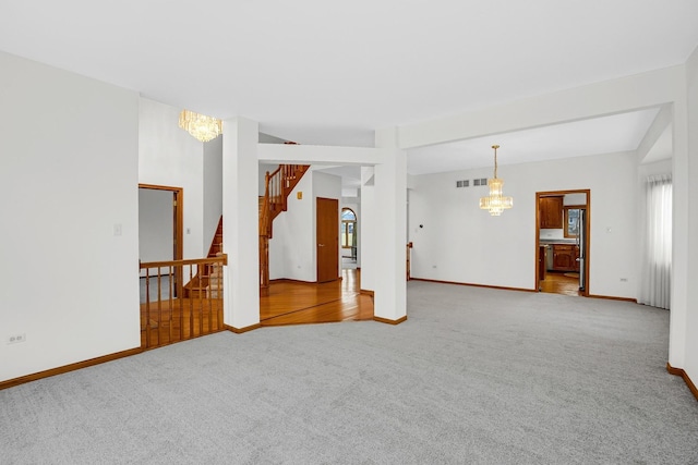 carpeted empty room with a notable chandelier