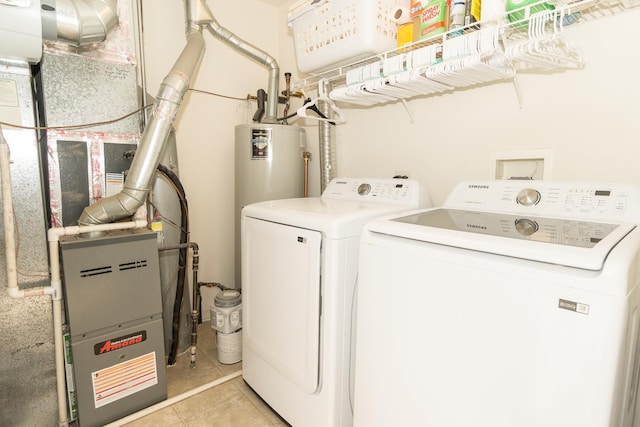 clothes washing area featuring light tile patterned floors and washer and clothes dryer