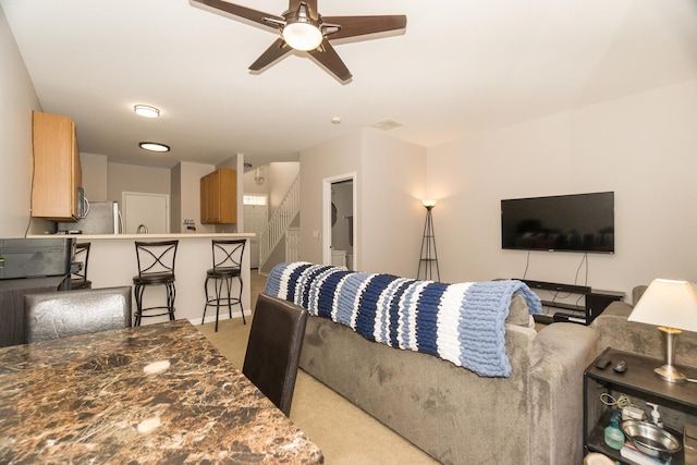 living room with light colored carpet and ceiling fan