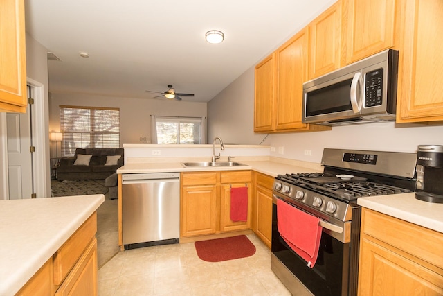 kitchen with appliances with stainless steel finishes, sink, light tile patterned floors, and ceiling fan