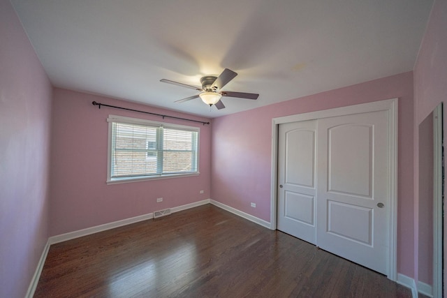 unfurnished bedroom with ceiling fan, dark hardwood / wood-style floors, and a closet