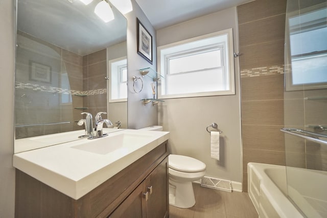 full bathroom with tiled shower / bath combo, vanity, and toilet