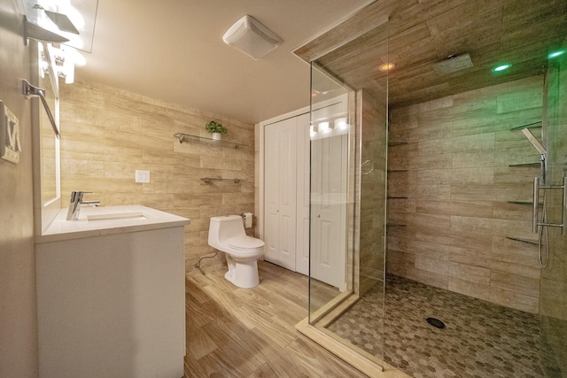 bathroom featuring a shower with door, vanity, hardwood / wood-style flooring, and toilet