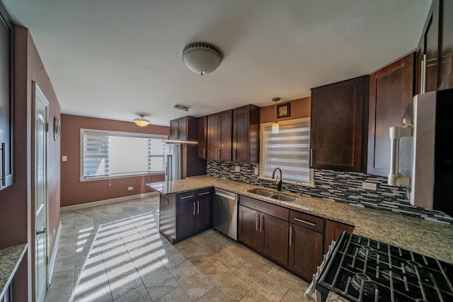 kitchen with sink, light stone counters, gas range, dishwasher, and decorative backsplash