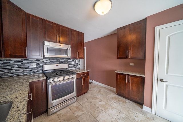 kitchen featuring stainless steel appliances, tasteful backsplash, light tile patterned flooring, and light stone counters