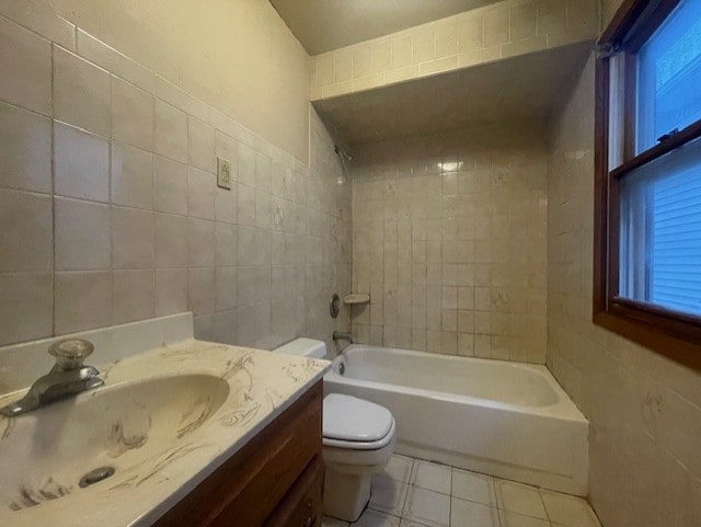 full bathroom with toilet, tile walls, vanity, tiled shower / bath combo, and tile patterned flooring