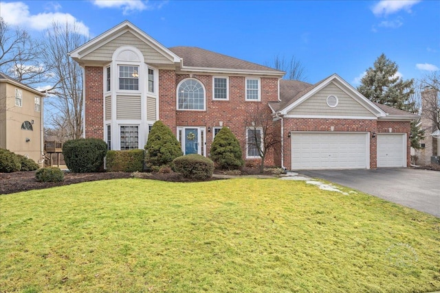 view of front facade with a garage, a front yard, brick siding, and driveway