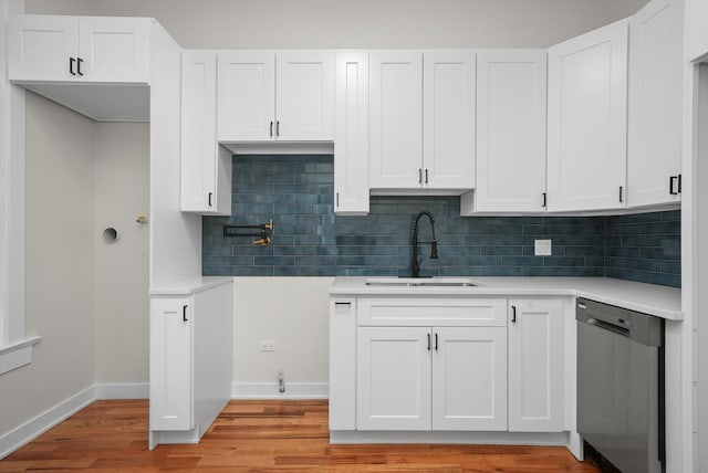 kitchen featuring white cabinetry, dishwasher, sink, and decorative backsplash