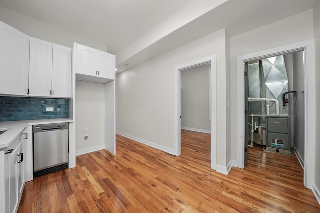 kitchen with tasteful backsplash, white cabinetry, dishwasher, and light wood-type flooring