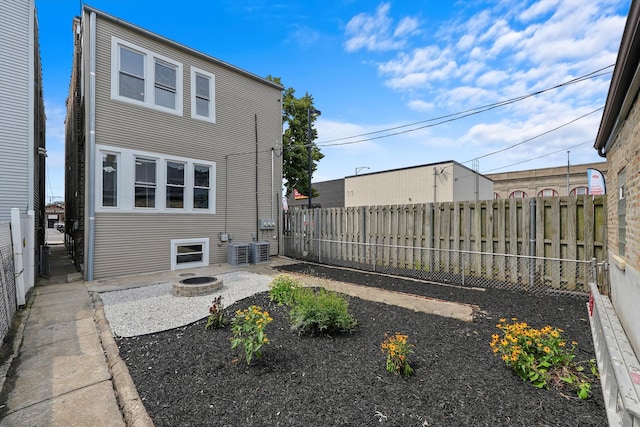 exterior space with central AC unit and an outdoor fire pit