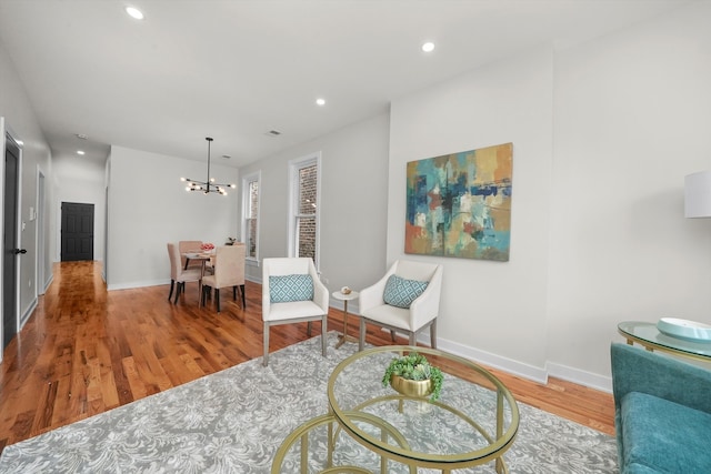 sitting room featuring hardwood / wood-style flooring and an inviting chandelier