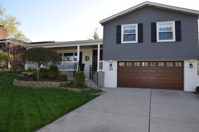 view of front of property with a garage, covered porch, and a front lawn