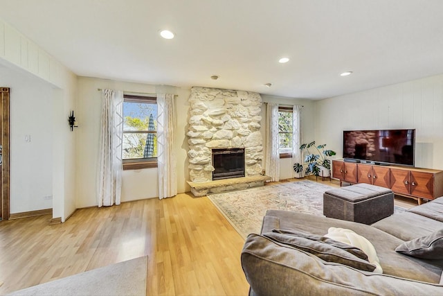 living room featuring hardwood / wood-style flooring and a stone fireplace