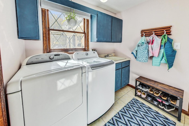 laundry area featuring light tile patterned flooring, cabinets, sink, and washing machine and clothes dryer