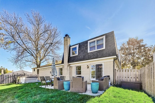 rear view of house featuring a hot tub, a patio, an outdoor hangout area, and a lawn