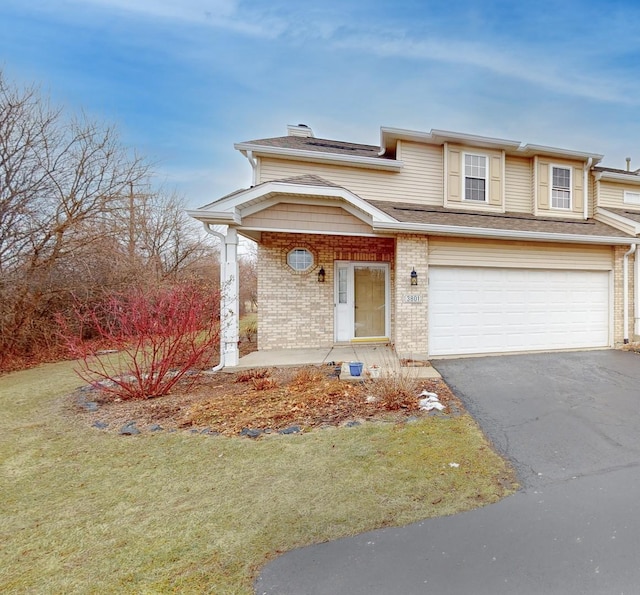 view of front of house with a garage and a front lawn