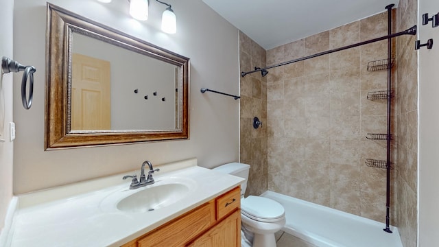 bathroom featuring vanity, toilet, and tiled shower