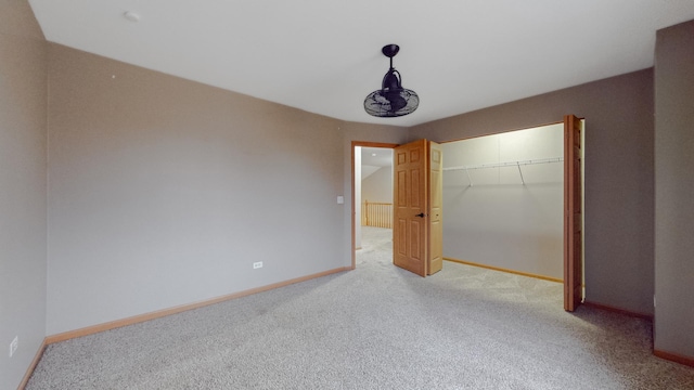 unfurnished bedroom featuring light colored carpet and a closet