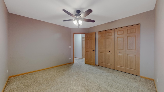 unfurnished bedroom with light carpet, a closet, and ceiling fan