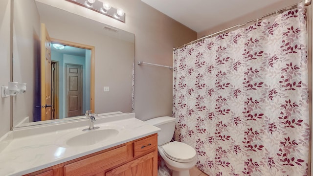 bathroom featuring a shower with curtain, vanity, and toilet