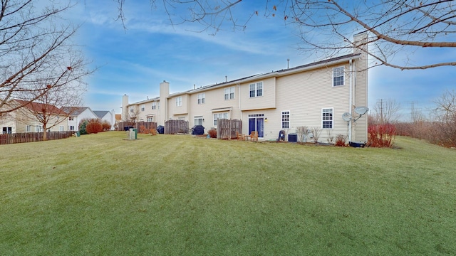 rear view of house with a yard and central AC unit