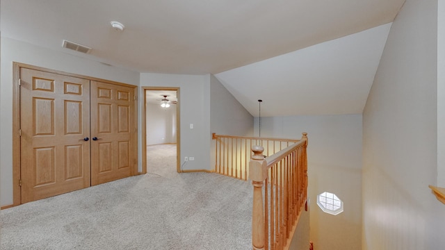 hallway featuring lofted ceiling and carpet flooring