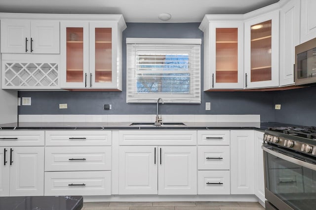 kitchen with stainless steel appliances, white cabinetry, and sink