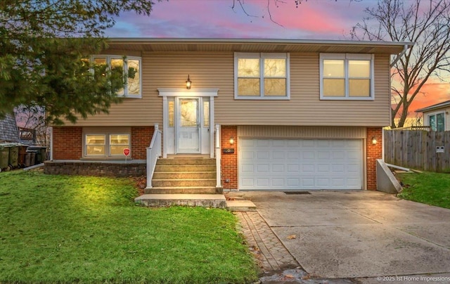 split foyer home featuring a garage and a yard