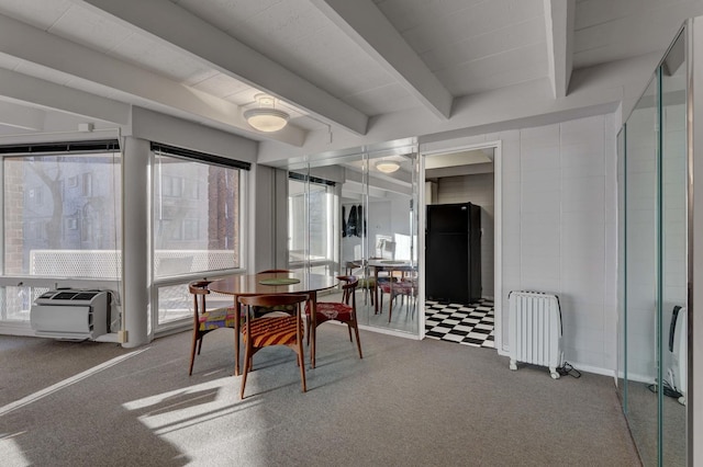 dining area with beamed ceiling, radiator heating unit, and carpet