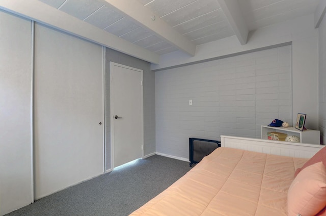 bedroom featuring dark carpet and beamed ceiling