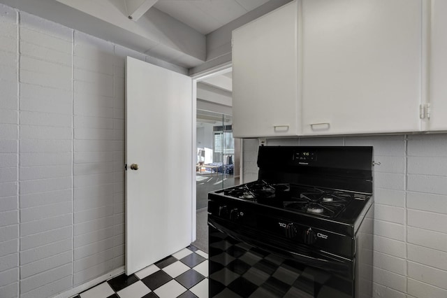 kitchen featuring black gas range and white cabinets