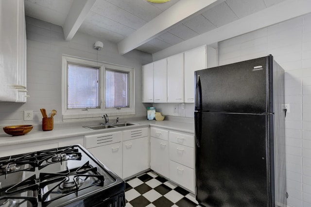 kitchen with beamed ceiling, white cabinets, sink, and black appliances