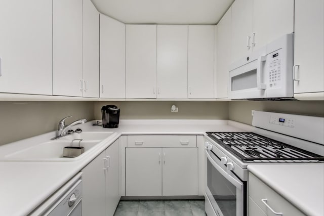 kitchen featuring sink, light tile patterned floors, white cabinets, and white appliances