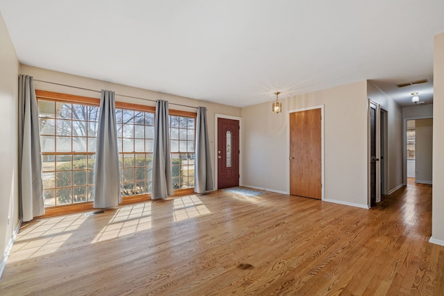 entryway featuring visible vents, baseboards, and wood finished floors