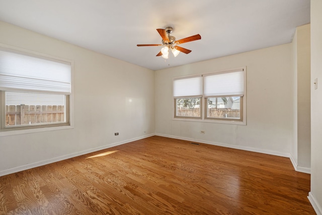 unfurnished room with a ceiling fan, baseboards, and wood finished floors