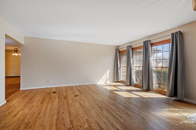 unfurnished room featuring visible vents, wood finished floors, and baseboards