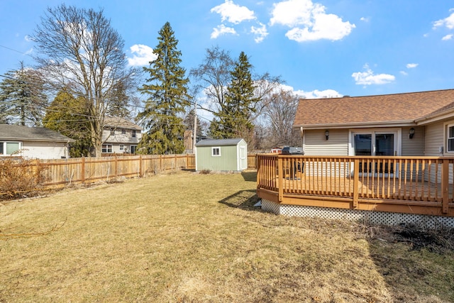 view of yard featuring a deck, an outbuilding, fence private yard, and a shed