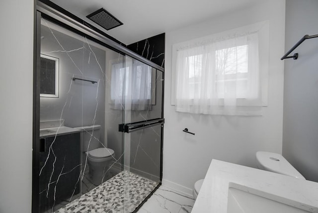 bathroom with toilet, vanity, and a shower with shower door