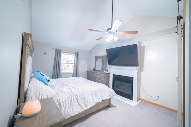 carpeted bedroom featuring lofted ceiling, a tile fireplace, and ceiling fan