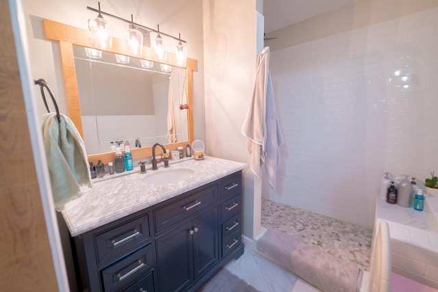 bathroom featuring tiled shower and vanity