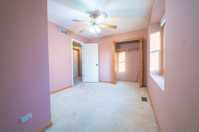 unfurnished bedroom with light carpet, a closet, and ceiling fan