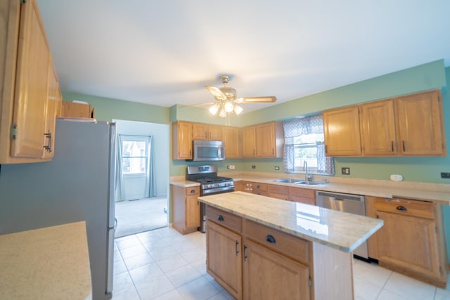 kitchen with stainless steel appliances, a center island, sink, and a wealth of natural light