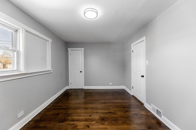 unfurnished room featuring dark wood-type flooring