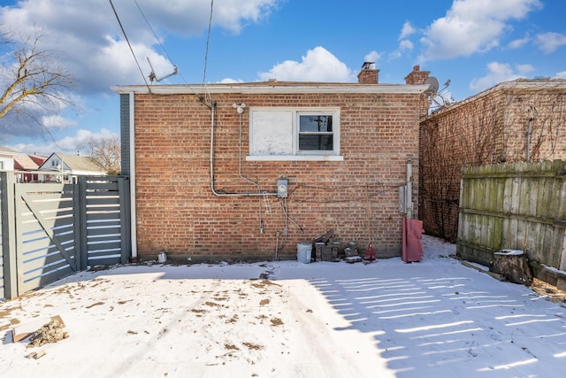 view of snow covered back of property